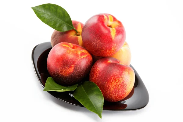 Verse perziken en nectarines op een plaat geïsoleerd op een witte achterzijde — Stockfoto