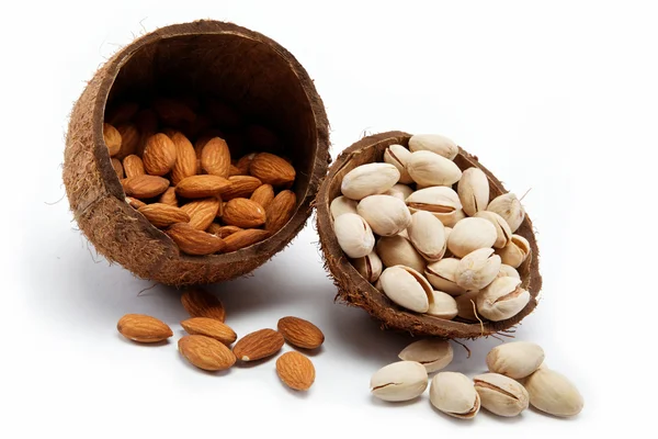 Almendras y pistachos en la cáscara del coco . — Foto de Stock