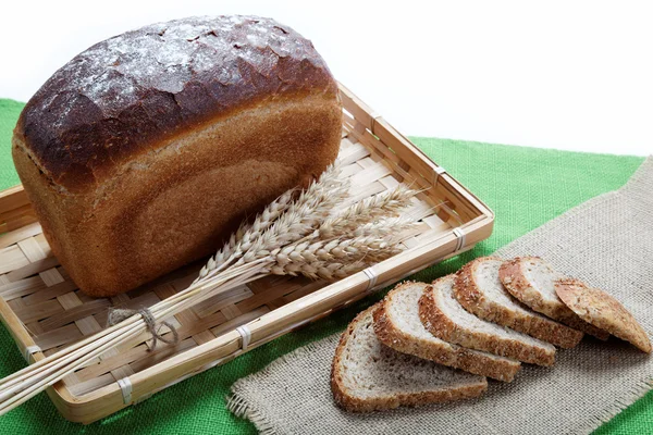 Pão fresco com espigas de trigo na tela . — Fotografia de Stock