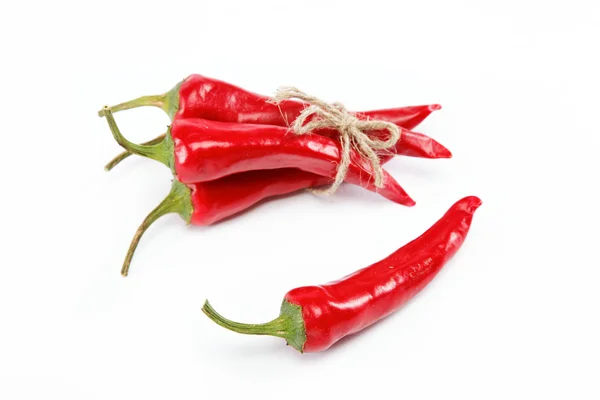 Czerwony hot chili peppers związany z lina na białym tle — Zdjęcie stockowe