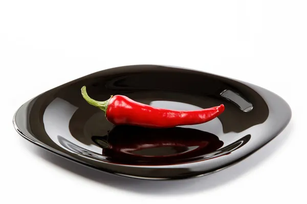 Rote scharfe Chilischote in einem schwarzen Teller mit einer Gabel, isoliert auf — Stockfoto