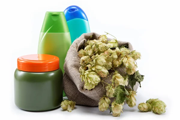 Bottles of shampoo and a bag of hops isolated on a white backgro — Stock Photo, Image