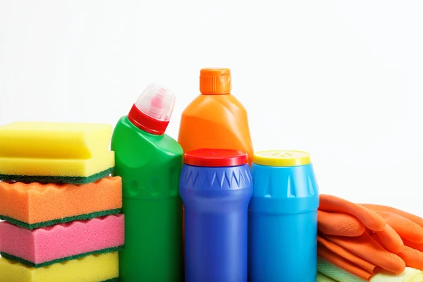 Frascos de detergente y esponja limpiadora sobre fondo blanco . — Foto de Stock