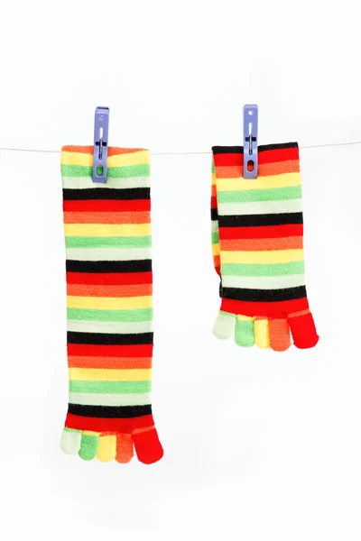 Bunte Spaßsocken an Wäscheklammern hängen an einem Seil. — Stockfoto