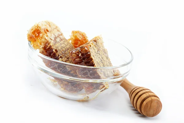 Peine de miel en un vaso y un rociador de madera, aislado en bac blanco —  Fotos de Stock