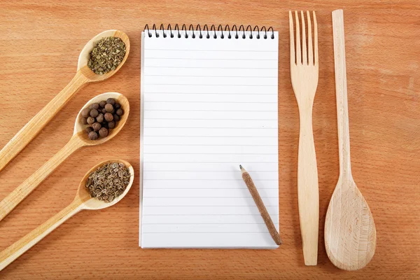 Cuaderno para recetas y especias en mesa de madera —  Fotos de Stock