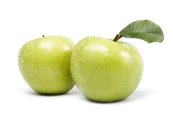Duas maçãs verdes em gotas de água em um fundo branco . — Fotografia de Stock