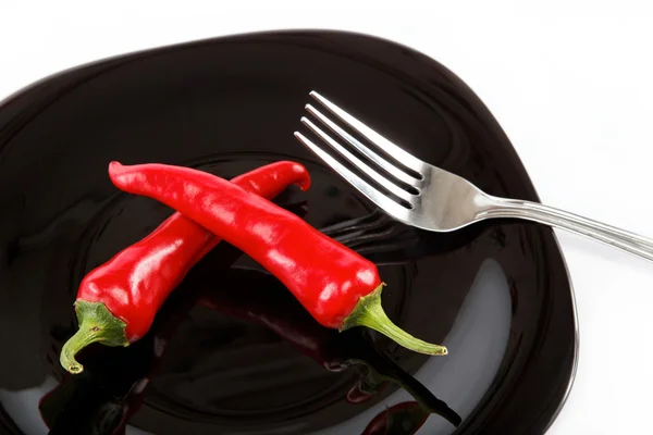 Red hot chili peppers in a black plate with a fork, isolated on — Stock Photo, Image