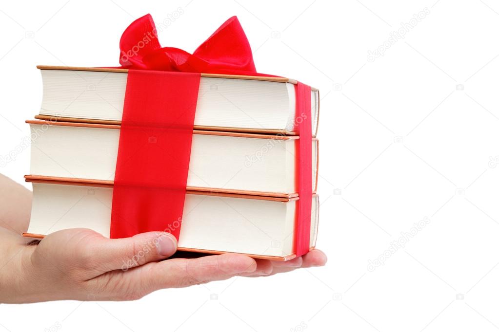Book as a gift. A stack of books in female hands on a white back