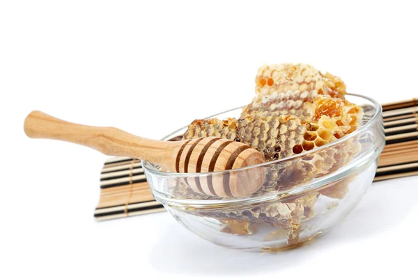 Honey comb in a glass bowl and wooden stick, isolated on white b — Stock Photo, Image