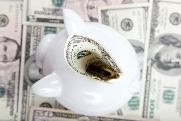 Sparschwein vor dem Hintergrund amerikanischer Dollarscheine. — Stockfoto