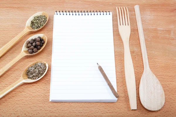 Cuaderno para recetas y especias en mesa de madera —  Fotos de Stock