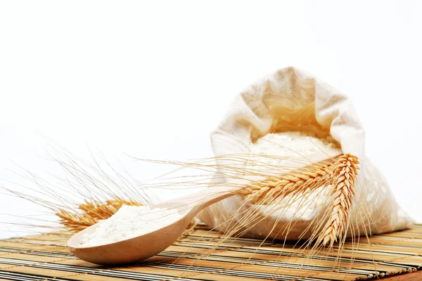 Harina y grano de trigo con cuchara de madera sobre una mesa de madera . —  Fotos de Stock