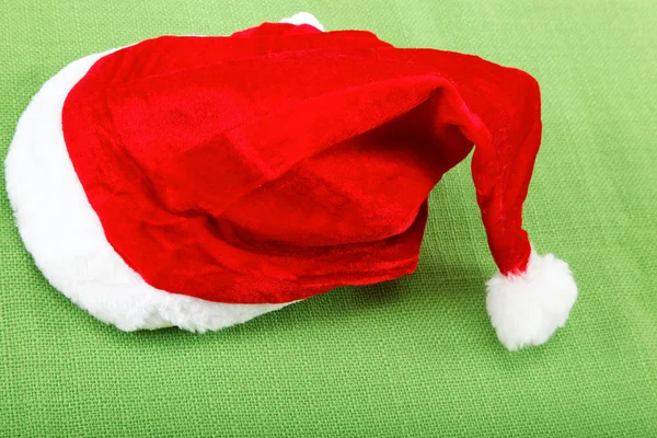 Santa Claus hat on the green cloth. — Stock Photo, Image