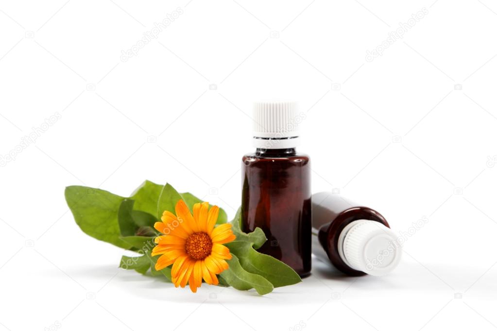 Medications and marigold flower isolated on white background.