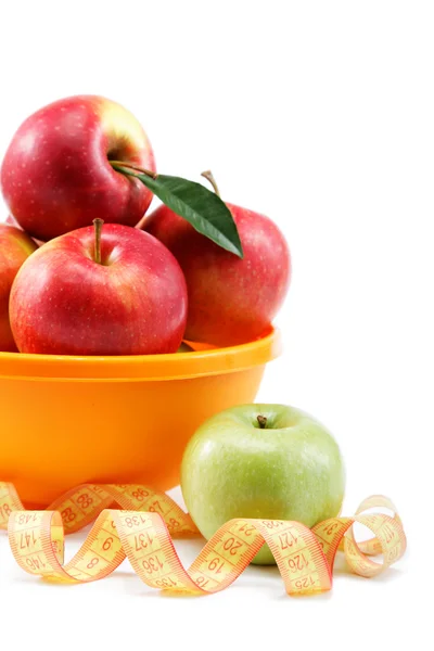 Pommes fraîches dans un bol et ruban à mesurer isolé sur le dos blanc — Photo