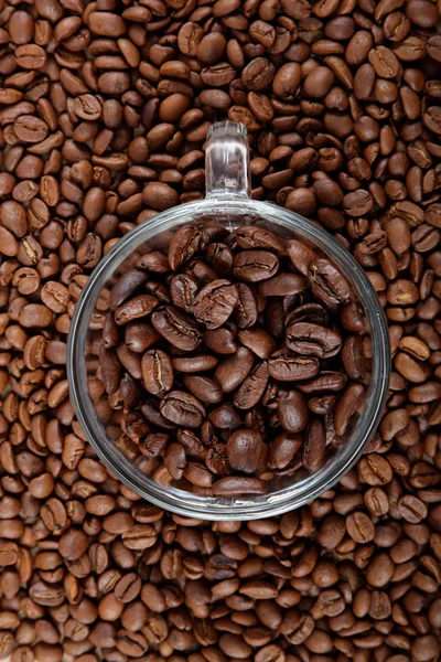 Glas kaffe cup på bakgrunden av kaffebönor. — Stockfoto