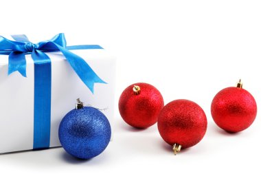 Beyaz hediye kutusu mavi şerit yay ve Noel topları ile,