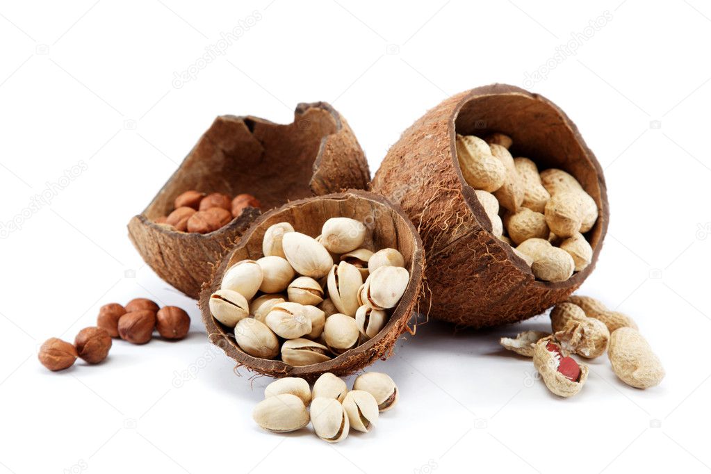 Pistachio, peanuts nuts and hazelnuts in the shell of the coconu