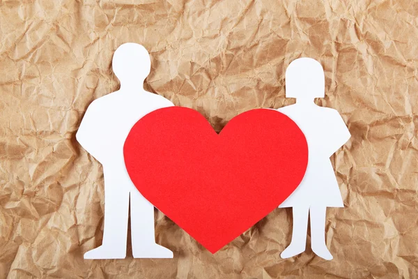 Siluetas de hombre, mujer y corazón cortadas de papel sobre ba marrón — Foto de Stock