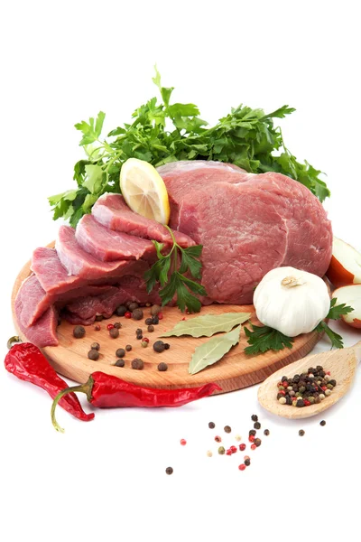 Carne crua, legumes e especiarias num isolado de tábua de corte de madeira — Fotografia de Stock