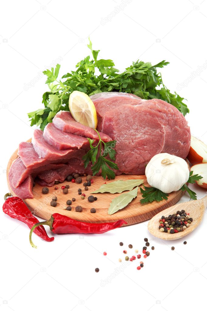 Raw meat, vegetables and spices on a wooden cutting board isolat