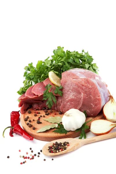 Surowe mięso, warzywa i przyprawy na drewniane cięcia pokładzie isolat — Zdjęcie stockowe