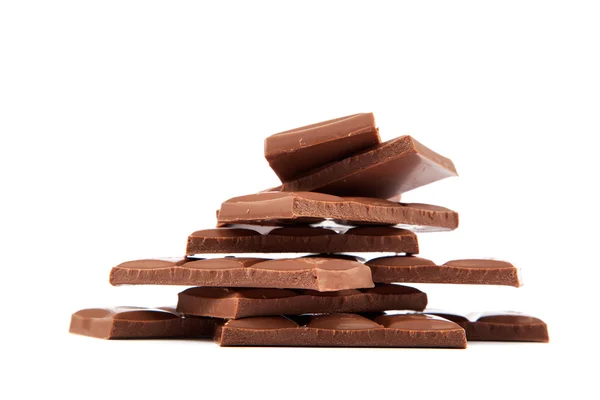 Pila de trozos de chocolate sobre un fondo blanco. — Foto de Stock