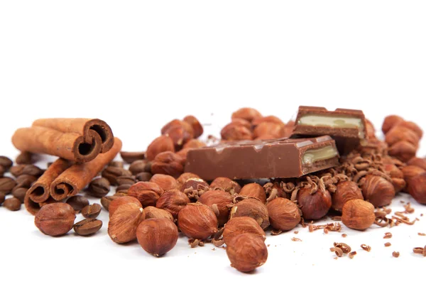 Stack of chocolate tiles with hazelnuts and cinnamon sticks on a — Stock Photo, Image