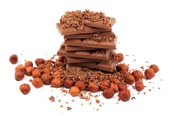 Stack of chocolate tiles with hazelnuts on a white background. — Stock Photo, Image