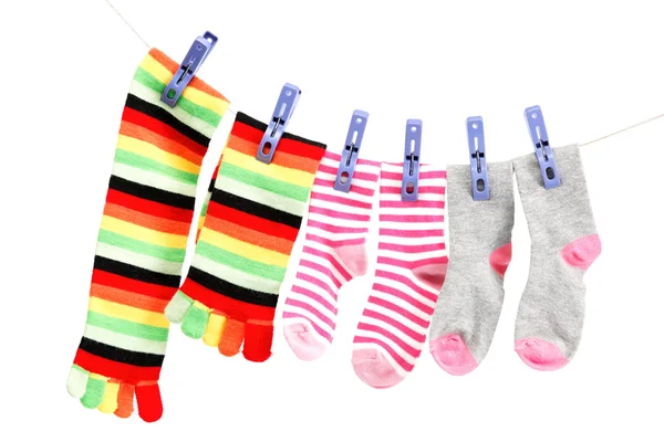 Bunte Socken auf einem Seil vor weißem Hintergrund. — Stockfoto