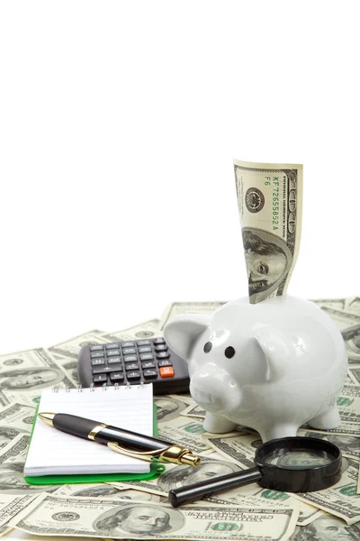 Piggy bank with a notebook, pen and calculator against the dolla — Stock Photo, Image