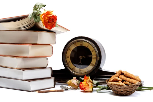 Una pila de libros, relojes antiguos y galletas sobre un fondo blanco — Foto de Stock