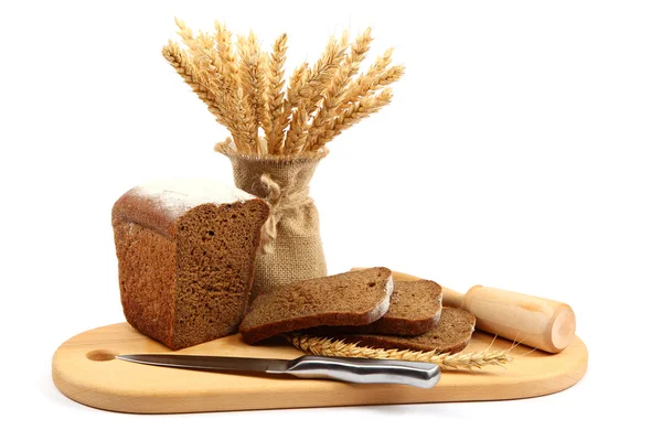 Frisches Brot und ein Weizenmesser auf dem Holzbrett. — Stockfoto