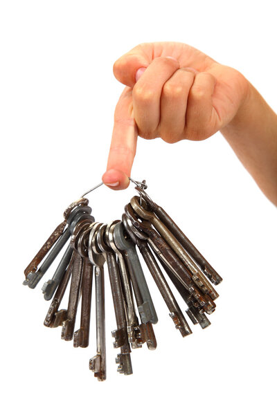 Bunch of old keys in hand isolated on a white background.