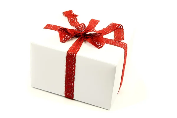 White box with red ribbon and bow isolated on a white background — Stock Photo, Image