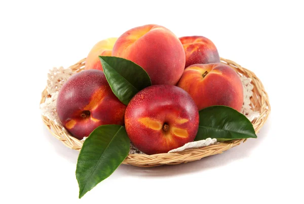Verse perziken en nectarines in een mand geïsoleerd op een witte bac — Stockfoto