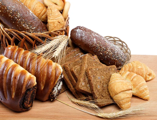 Fresh bread with ears of wheat on a wooden table. — Stock Photo, Image