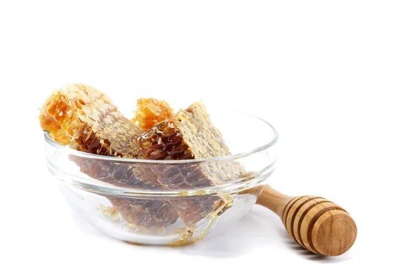 Honey comb in a glass bowl and wooden stick, isolated on white b — Stock Photo, Image