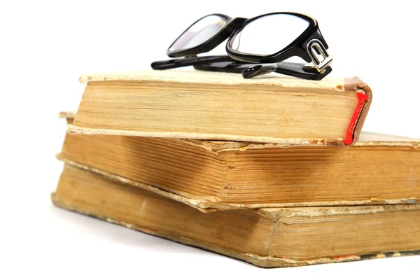 Verem a régi könyvek és a fehér alapon szemüveg. — Stock Fotó