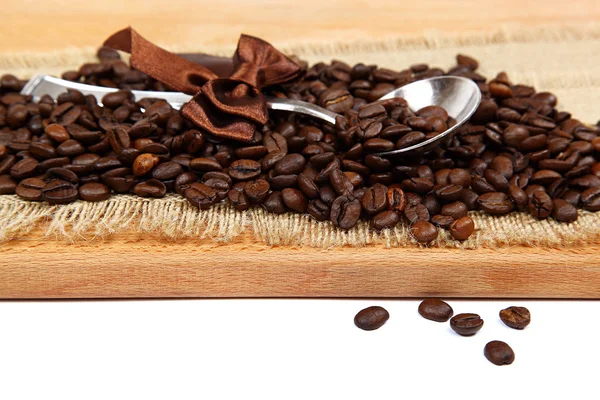 Roasted coffee beans and a metal spoon on a wooden board. — Stock Photo, Image