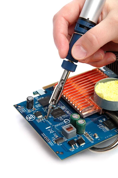 Soldering iron in hand and electric board on a white background. — Stock Photo, Image