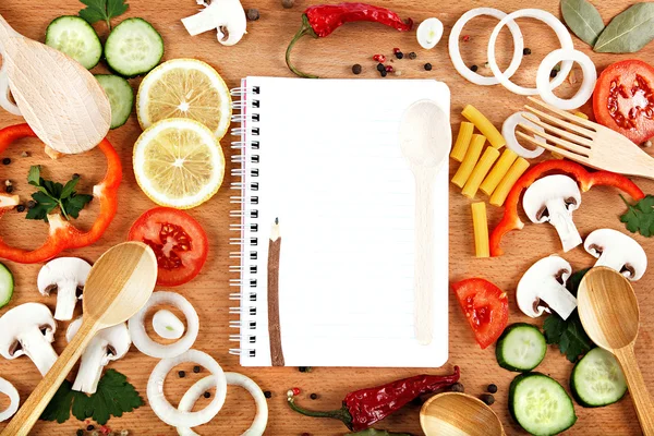 Vegetables, spices and recipes notepad on wooden cutting board. — Stock Photo, Image