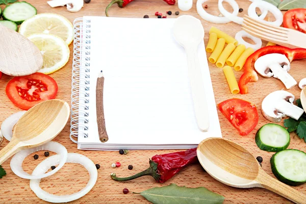 Warzywa, przyprawy i przepisy notatnik na drewnianą deską do krojenia. — Zdjęcie stockowe