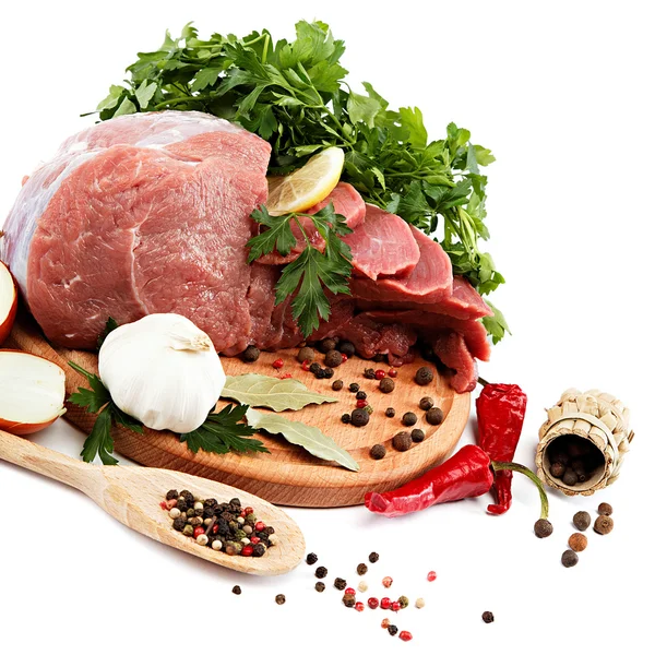 Raw meat, vegetables and spices on a wooden cutting board. — Stock Photo, Image