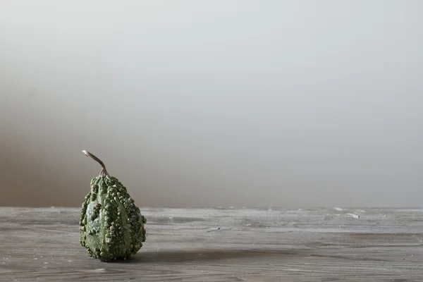 Green pumpkin cute on wooden table — Stock Photo, Image