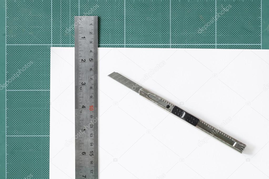 Green cutting mats withi iron ruler and cuter isolated on white Stock