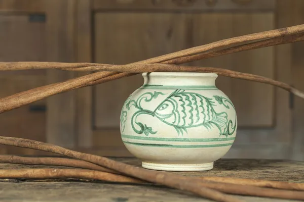 Antique ceramic paint bowl with stick on cabinet wooden background (Still life) — Stock Photo, Image