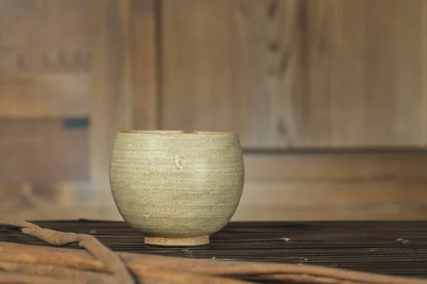Antique tigela de cerâmica com vara no armário de fundo de madeira (Natureza morta ) — Fotografia de Stock