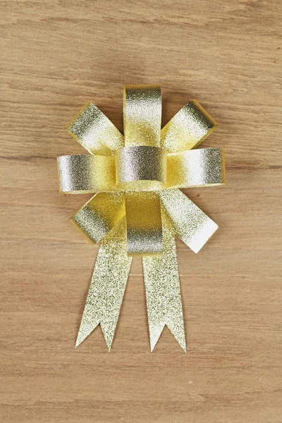 Golden ribbon on wooden background — Stock Photo, Image